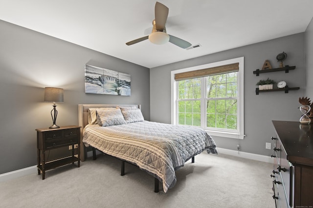 bedroom with baseboards, light carpet, visible vents, and a ceiling fan