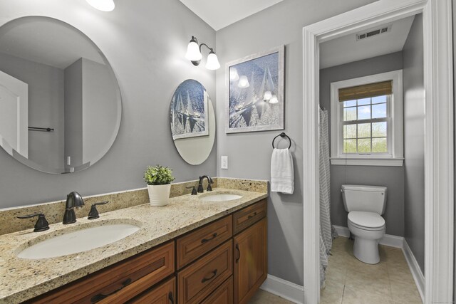full bath with double vanity, toilet, visible vents, and a sink