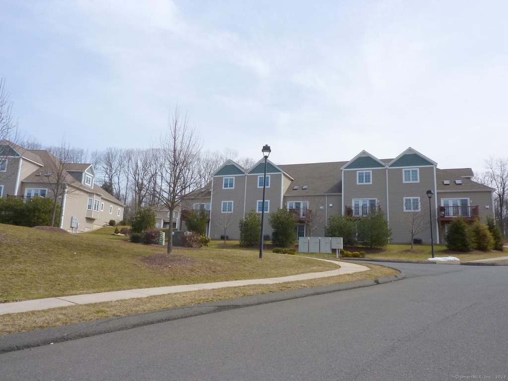 view of street featuring curbs, a residential view, street lighting, and sidewalks