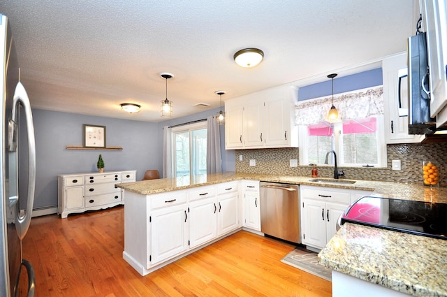 187 Hollister Dr, Avon, CT 06001 - kitchen with a sink, light wood-style flooring, a peninsula, tasteful backsplash, and appliances with stainless steel finishes