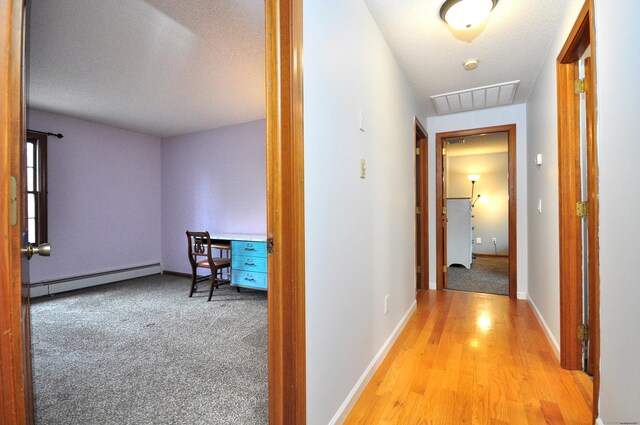 187 Hollister Dr, Avon, CT 06001 - hallway featuring a baseboard radiator, wood finished floors, a textured ceiling, baseboards, and visible vents