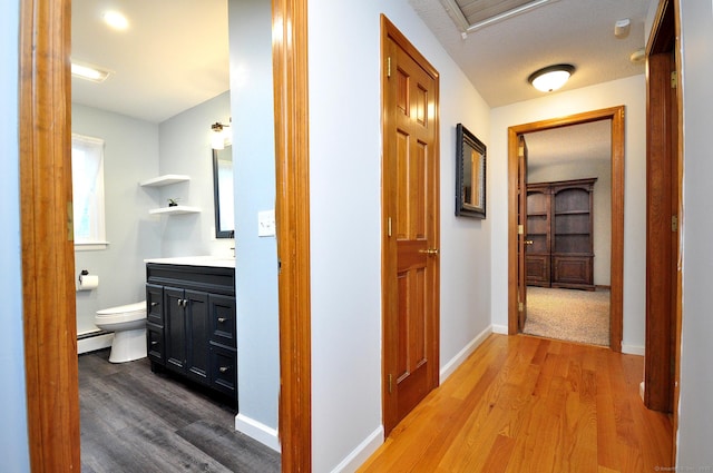 187 Hollister Dr, Avon, CT 06001 - hallway with baseboards, wood finished floors, and a baseboard radiator