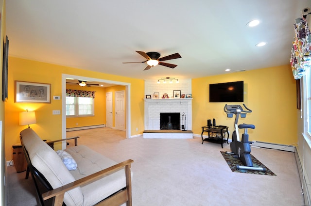 living area featuring a baseboard radiator, ceiling fan, light colored carpet, baseboard heating, and a fireplace