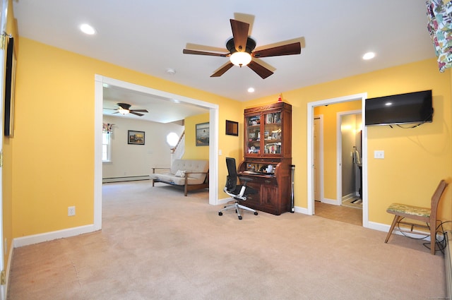 office featuring baseboard heating, baseboards, a ceiling fan, and light colored carpet