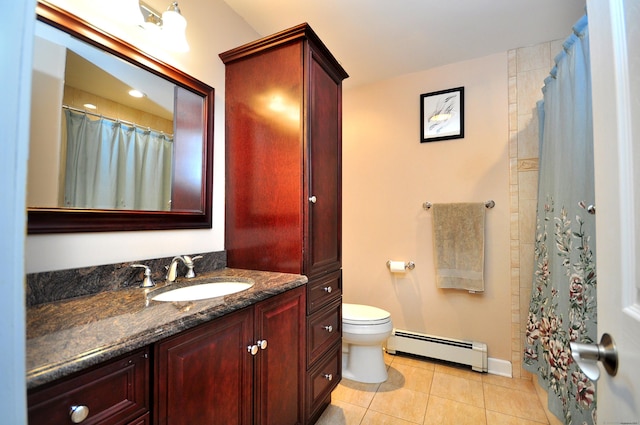bathroom featuring tile patterned flooring, baseboard heating, toilet, vanity, and baseboards