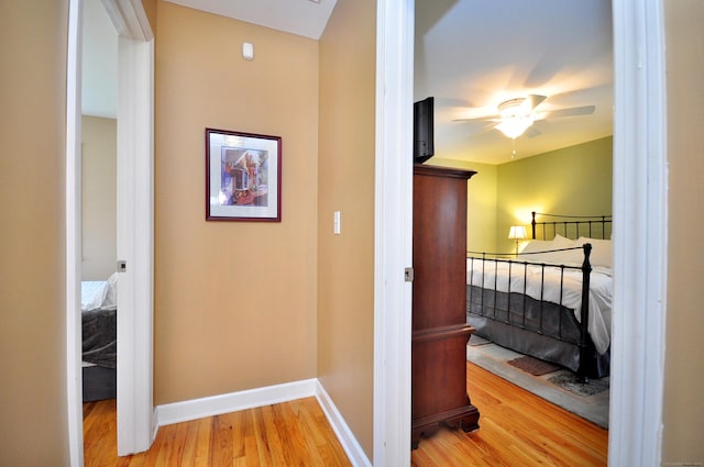 corridor with baseboards and wood finished floors
