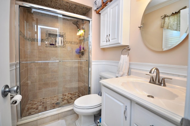 full bathroom featuring vanity, toilet, a shower stall, and wainscoting