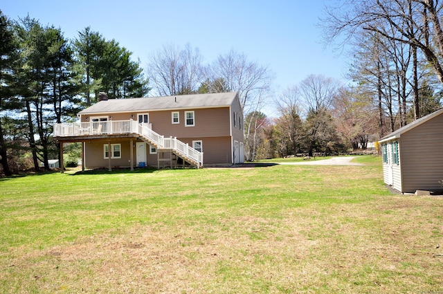 rear view of house featuring a deck, stairway, a chimney, and a lawn