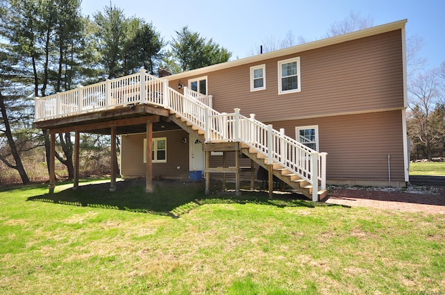 rear view of house with a deck, a yard, and stairs