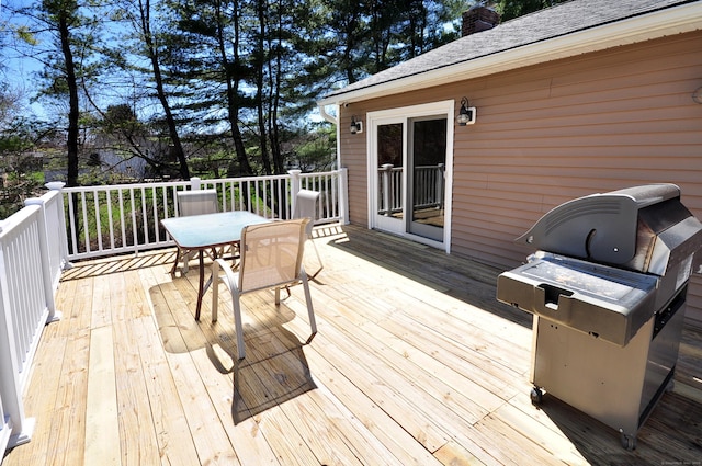wooden deck with grilling area and outdoor dining area
