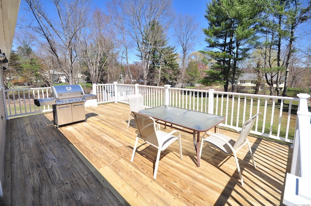 deck with area for grilling, outdoor dining area, and a yard