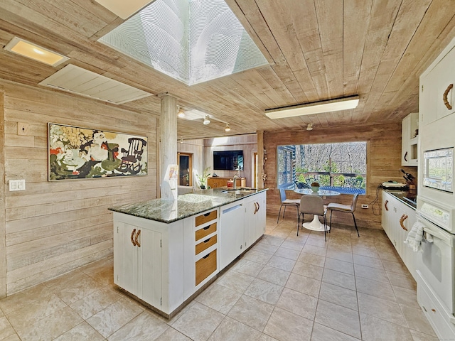 1177 Rock Rimmon Rd, Stamford, CT 06903 - kitchen featuring wood ceiling, white cabinetry, a sink, wooden walls, and white appliances