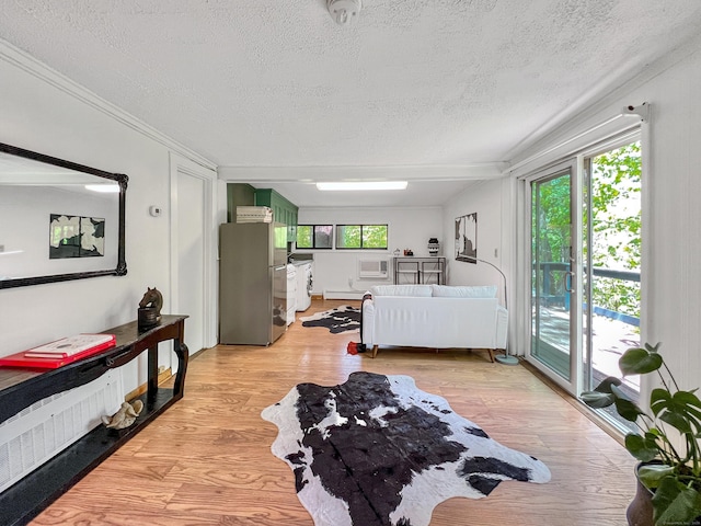 1177 Rock Rimmon Rd, Stamford, CT 06903 - interior space featuring laundry area, light wood-style floors, a wall unit AC, a textured ceiling, and crown molding