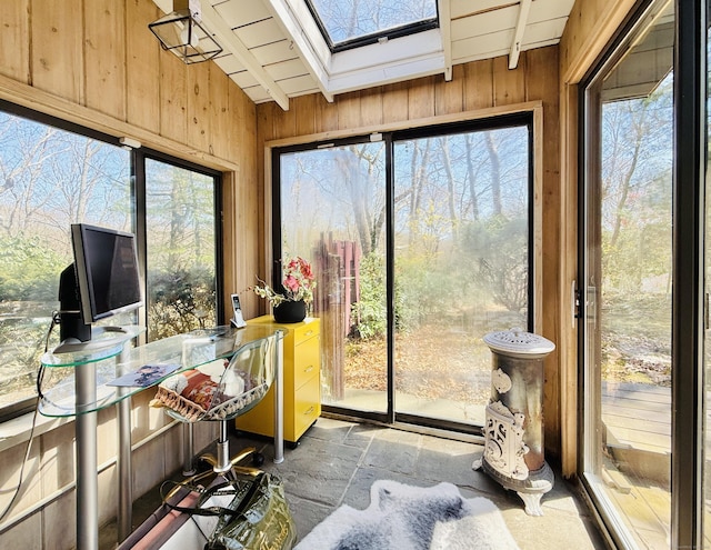 1177 Rock Rimmon Rd, Stamford, CT 06903 - sunroom featuring wooden walls, vaulted ceiling with skylight, and stone finish flooring