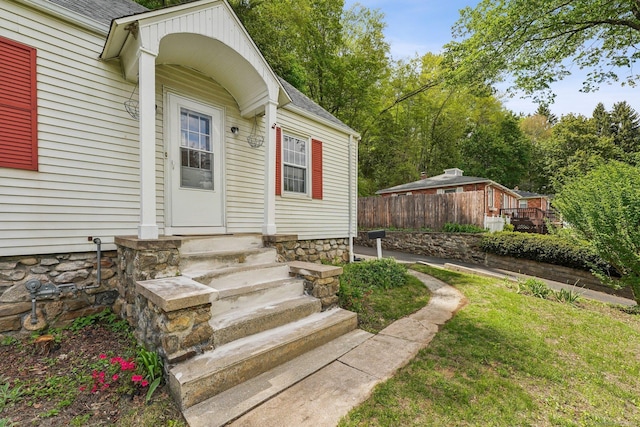 doorway to property featuring roof with shingles