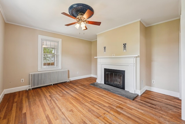 unfurnished living room with radiator, a glass covered fireplace, light wood-type flooring, a ceiling fan, and ornamental molding