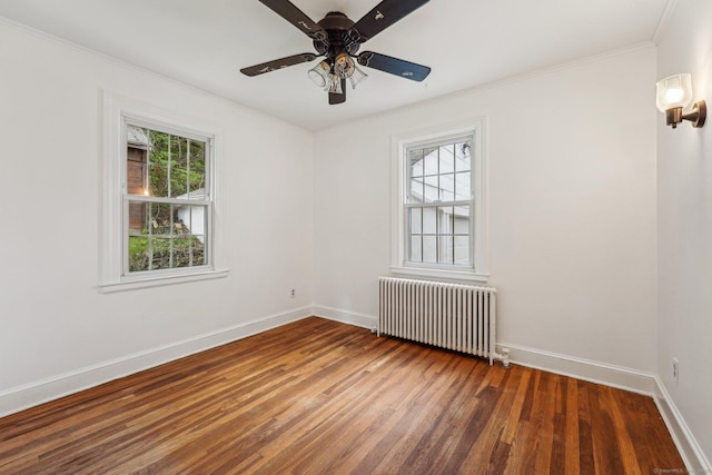unfurnished room with radiator, wood finished floors, crown molding, baseboards, and a ceiling fan