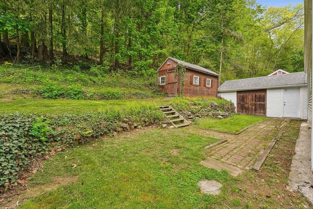 view of green lawn featuring an outbuilding
