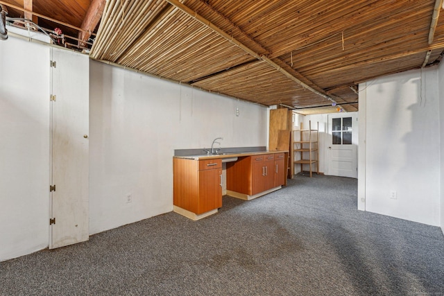 finished below grade area featuring dark carpet and a sink