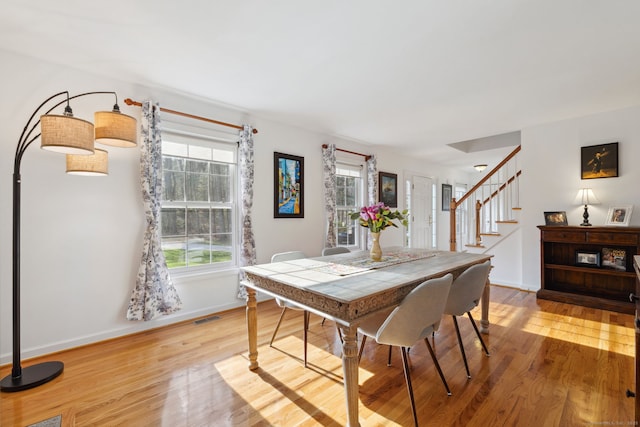 dining area with stairway, visible vents, baseboards, and light wood-style floors