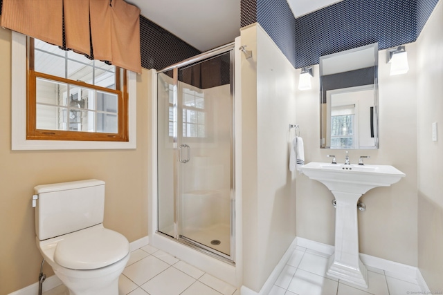 bathroom with toilet, tile patterned flooring, a stall shower, and baseboards