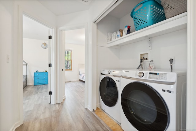 washroom with separate washer and dryer, baseboards, laundry area, and light wood-type flooring