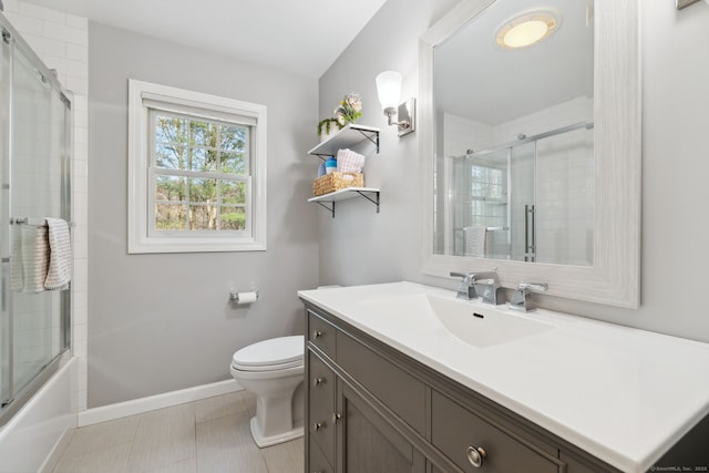 bathroom with baseboards, toilet, combined bath / shower with glass door, and vanity