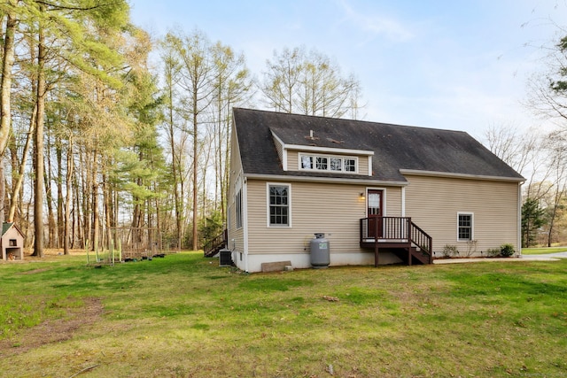 rear view of property featuring a yard and central AC unit