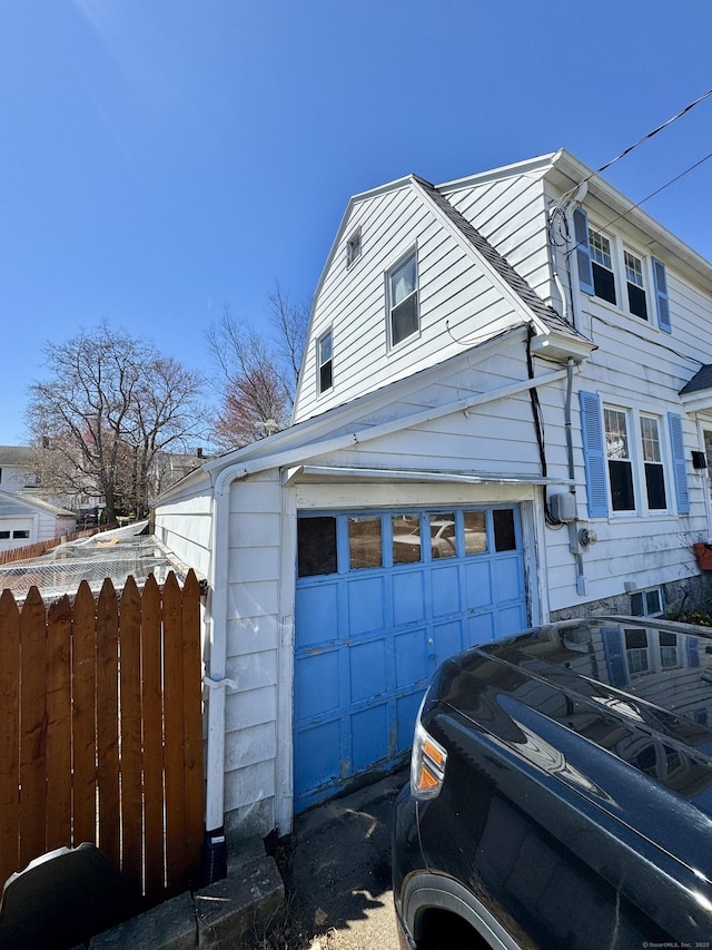 view of side of property featuring a garage and fence
