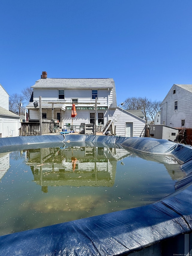 rear view of property featuring a chimney and a water view