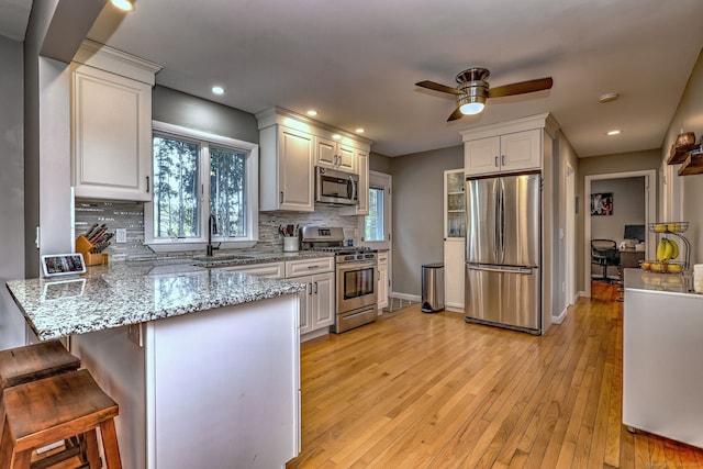 245 Paradise Ave, Hamden, CT 06514 - kitchen featuring ceiling fan, appliances with stainless steel finishes, a sink, a peninsula, and backsplash
