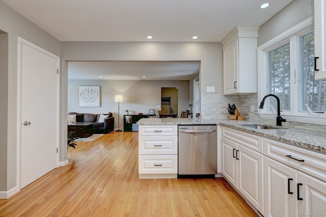 245 Paradise Ave, Hamden, CT 06514 - kitchen featuring tasteful backsplash, stainless steel dishwasher, white cabinetry, a sink, and light wood-style flooring