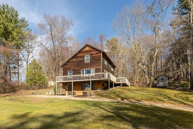 43 Greene Ave, North Canaan, CT 06018 - rear view of house with a wooden deck, a storage unit, an outbuilding, a lawn, and stairway