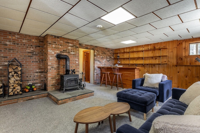 43 Greene Ave, North Canaan, CT 06018 - living area featuring carpet floors, a wood stove, a bar, and wood walls