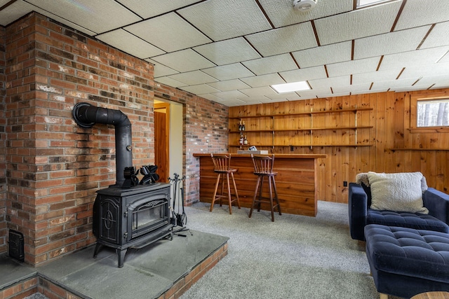 43 Greene Ave, North Canaan, CT 06018 - carpeted living area with a wood stove, wooden walls, and a bar