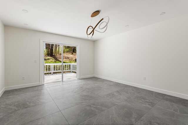 unfurnished room featuring marble finish floor, baseboards, and a chandelier