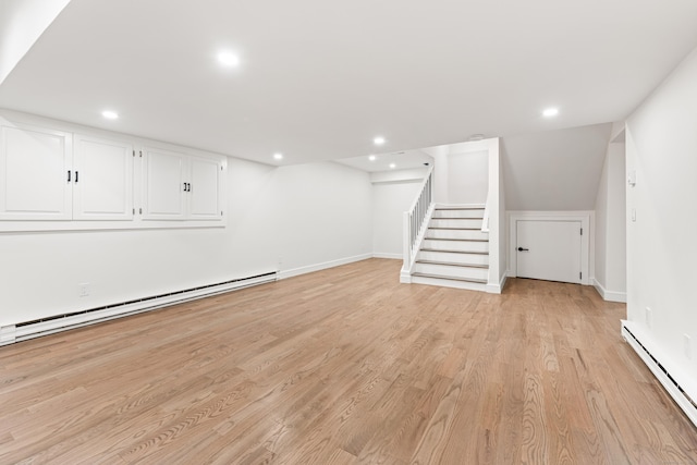 finished basement with baseboard heating, recessed lighting, and stairway