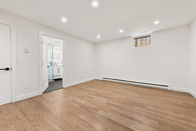 interior space with light wood finished floors, baseboards, recessed lighting, and a baseboard radiator