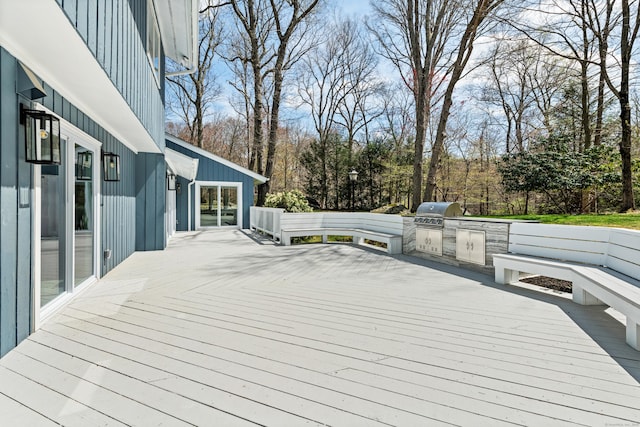 wooden deck with area for grilling and exterior kitchen