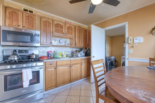 203 Westminster St, Hartford, CT 06112 - kitchen with stainless steel appliances, washing machine and clothes dryer, a sink, backsplash, and a ceiling fan