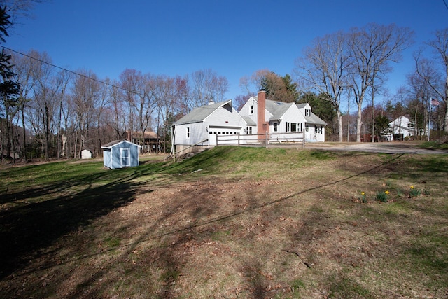95 Hop Brook Rd, Simsbury, CT 06070 - view of property exterior featuring a chimney, a lawn, driveway, and an attached garage