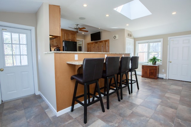 95 Hop Brook Rd, Simsbury, CT 06070 - kitchen with freestanding refrigerator, baseboards, a baseboard heating unit, a peninsula, and light stone counters
