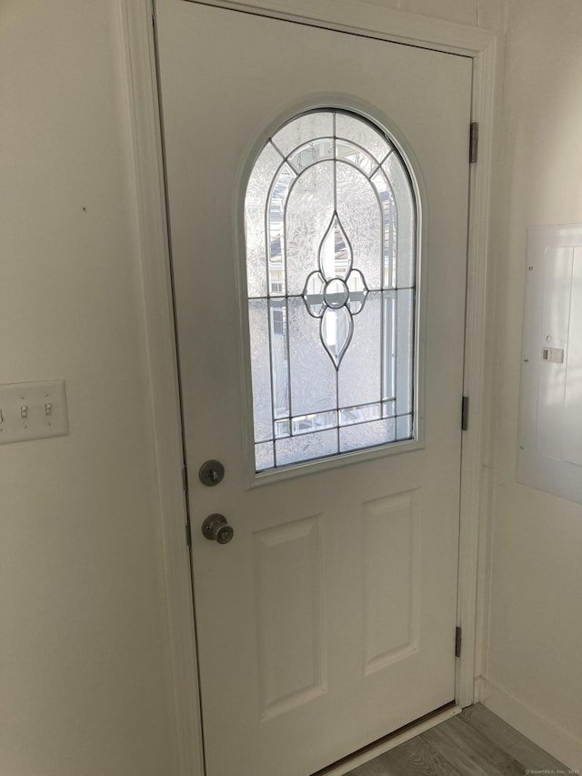 doorway to outside featuring baseboards and electric panel