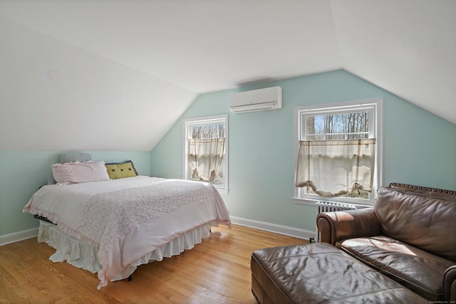 bedroom featuring vaulted ceiling, light wood-style flooring, multiple windows, and a wall unit AC