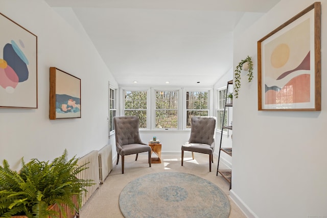 living area featuring baseboards, recessed lighting, light colored carpet, and radiator