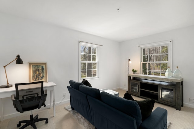 living area with light colored carpet and baseboards