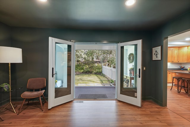 doorway featuring baseboards, recessed lighting, visible vents, and light wood-type flooring