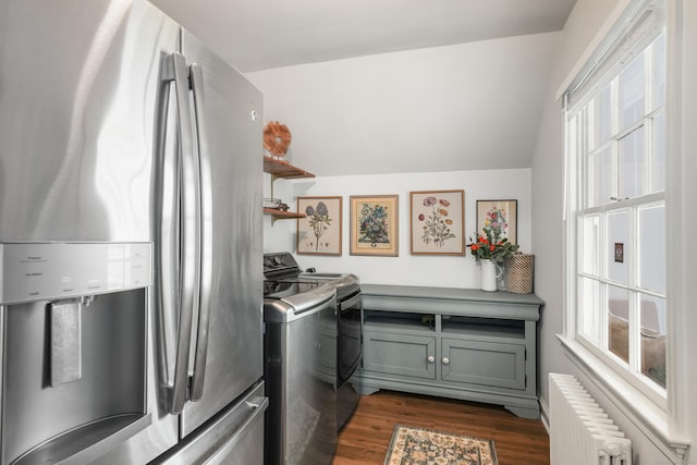 clothes washing area with washer and dryer, radiator heating unit, dark wood-type flooring, and laundry area