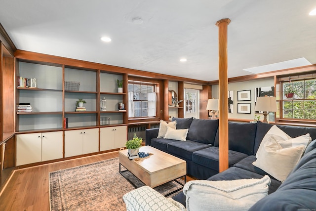 living area featuring radiator heating unit, wood finished floors, and recessed lighting