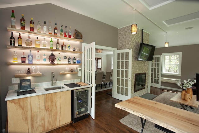 18 Cardinal Rd, Weston, CT 06883 - indoor wet bar featuring wine cooler, dark wood-type flooring, a large fireplace, pendant lighting, and french doors